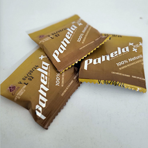 Tres sobres de Panela Plus de 6 gramos, endulzante natural 100% puro, sobre fondo neutro.