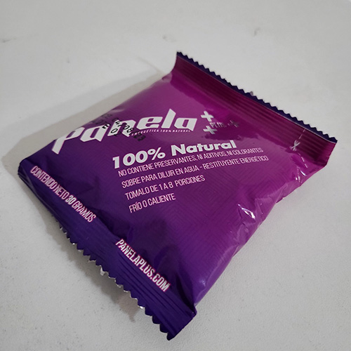 Sobre de Panela Plus de 30 gramos, etiquetado como 100% Natural, en empaque morado sobre fondo claro.